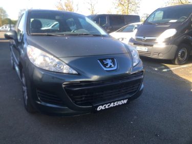Citadine noire : Une voiture compacte noire de marque Peugeot.
