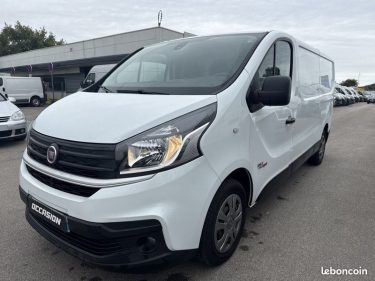 Fourgon blanc : Un utilitaire blanc de taille moyenne.